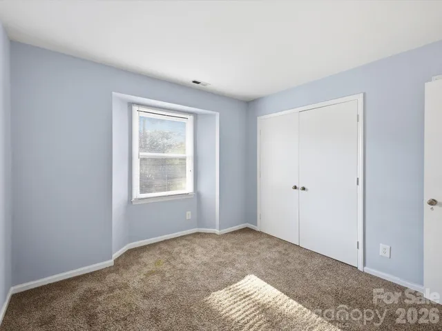 a view of a big room with closet and windows