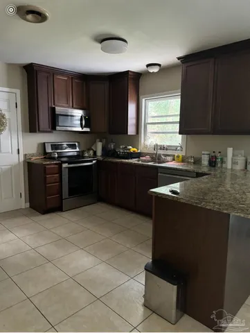 a kitchen with stainless steel appliances granite countertop a stove a sink dishwasher and a refrigerator
