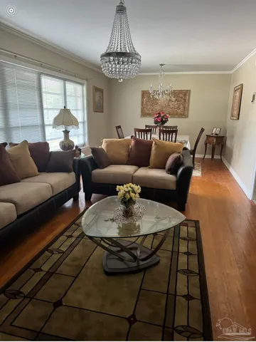 a living room with furniture and a chandelier