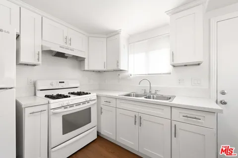 a kitchen with cabinets appliances a sink and a window