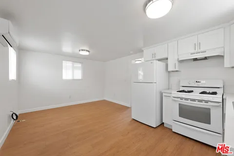a kitchen with cabinets appliances and wooden floor