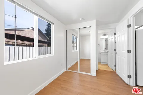 a view of a hallway with wooden floor and windows