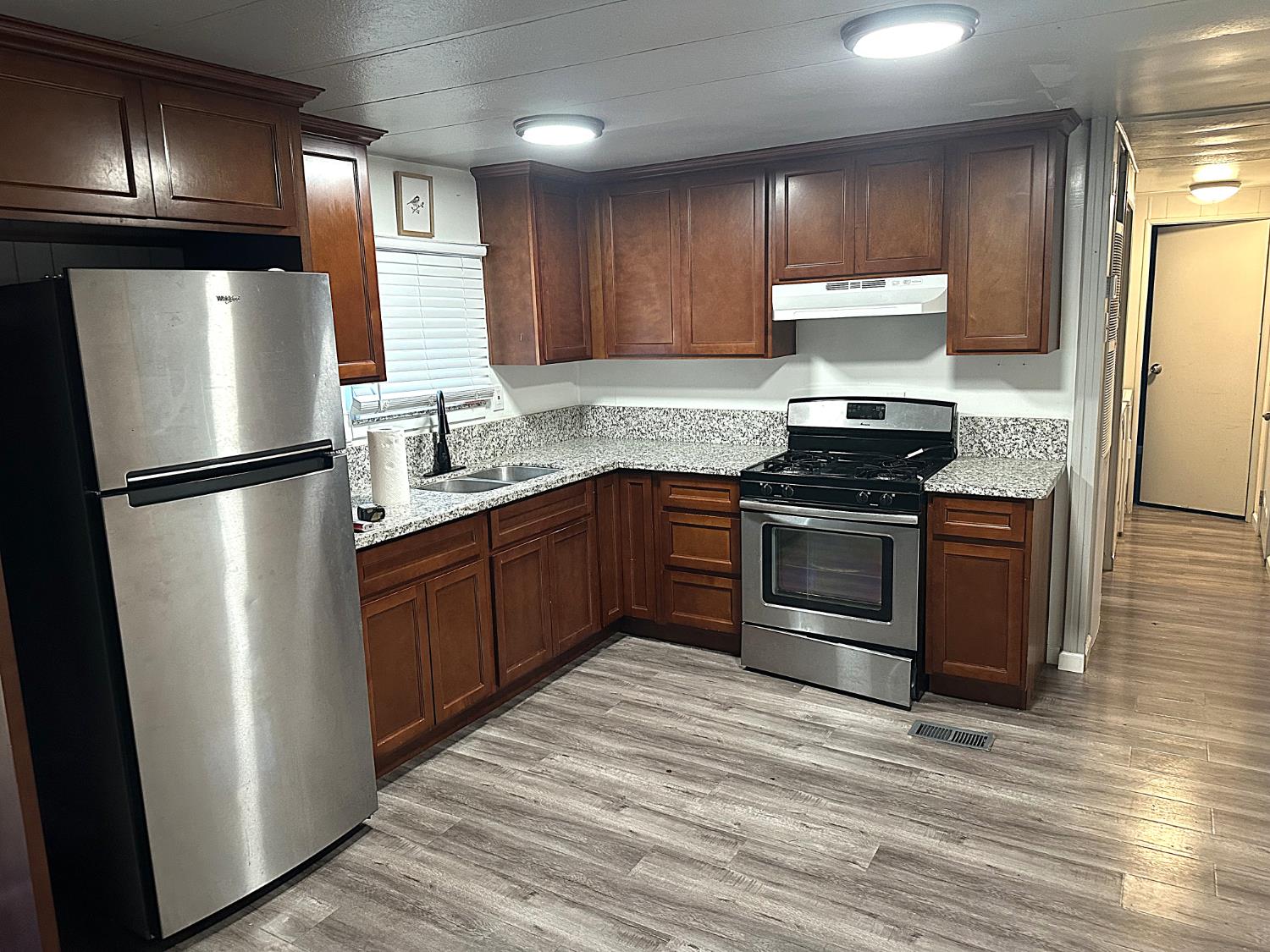 13955 West Walnut Grove Road, Unit 16 Walnut Grove, CA 95690 - Photo 6 of 18 a kitchen with stainless steel appliances granite countertop a refrigerator stove a sink dishwasher and microwave
