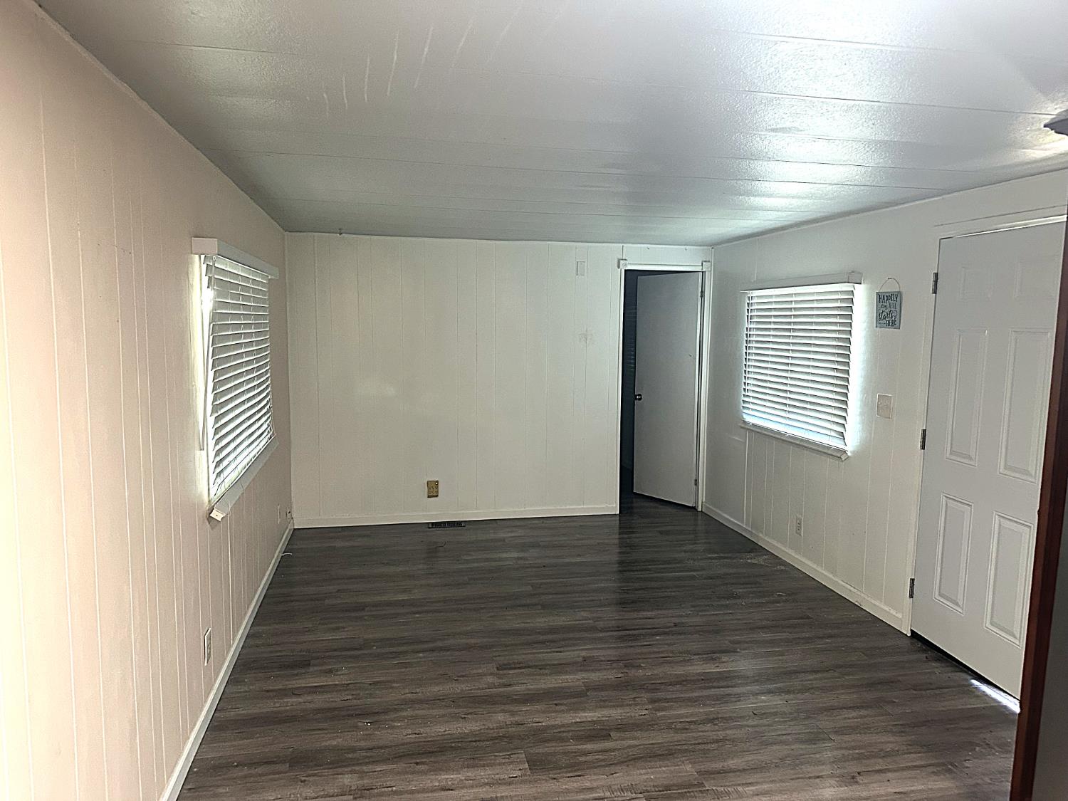 13955 West Walnut Grove Road, Unit 16 Walnut Grove, CA 95690 - Photo 8 of 18 an empty room with wooden floor and windows