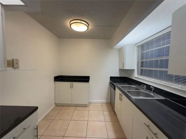 a kitchen with a refrigerator and a sink