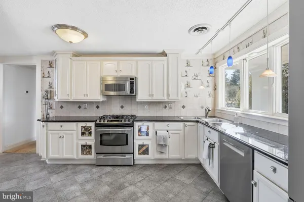 a kitchen with stainless steel appliances granite countertop a stove and a sink