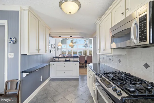 a kitchen with stainless steel appliances a stove a sink and a microwave