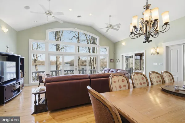 a view of a dining room with furniture a chandelier and wooden floor