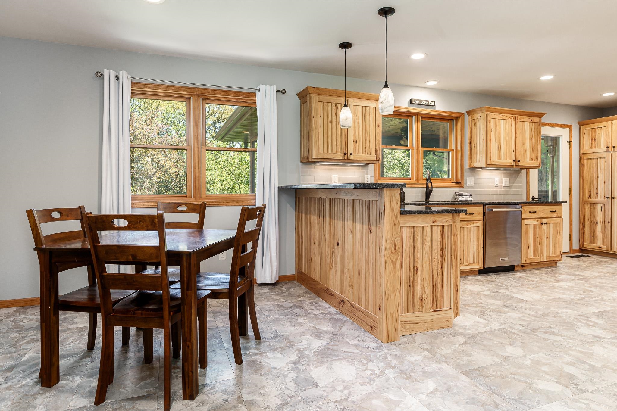 10249 Atwood Road Roscoe, IL 61073 - Photo 15 of 58 a kitchen with stainless steel appliances kitchen island granite countertop a table chairs and a refrigerator
