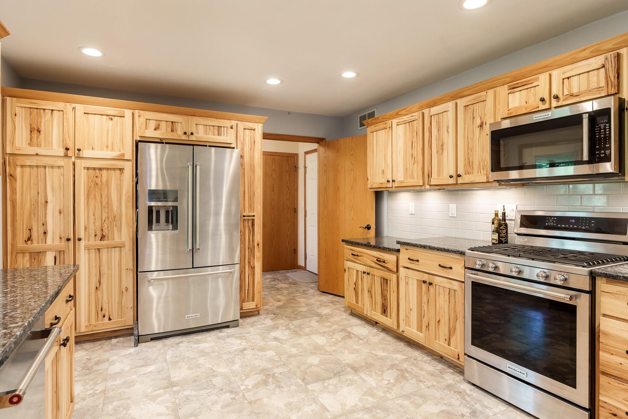10249 Atwood Road Roscoe, IL 61073 - Photo 19 of 58 a kitchen with stainless steel appliances granite countertop a refrigerator stove and microwave