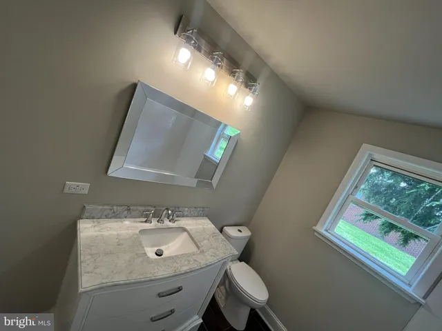 a bathroom with a toilet sink and mirror