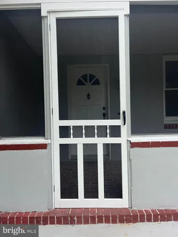 a living room with patio furniture and a potted plant