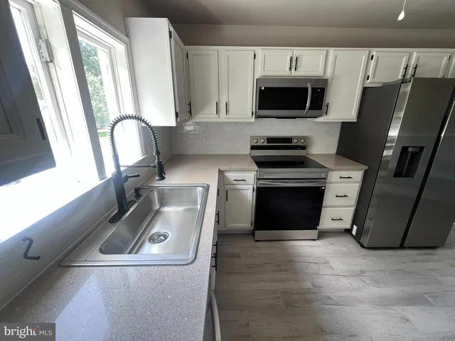 a view of a kitchen with a sink stove and a window