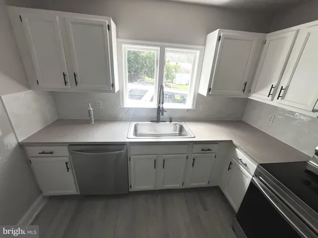 a kitchen with granite countertop a sink and a stove
