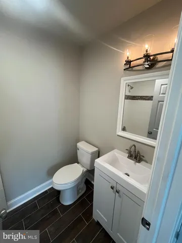 a bathroom with a granite countertop toilet and sink