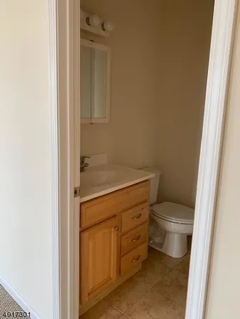 a bathroom with a granite countertop toilet and sink