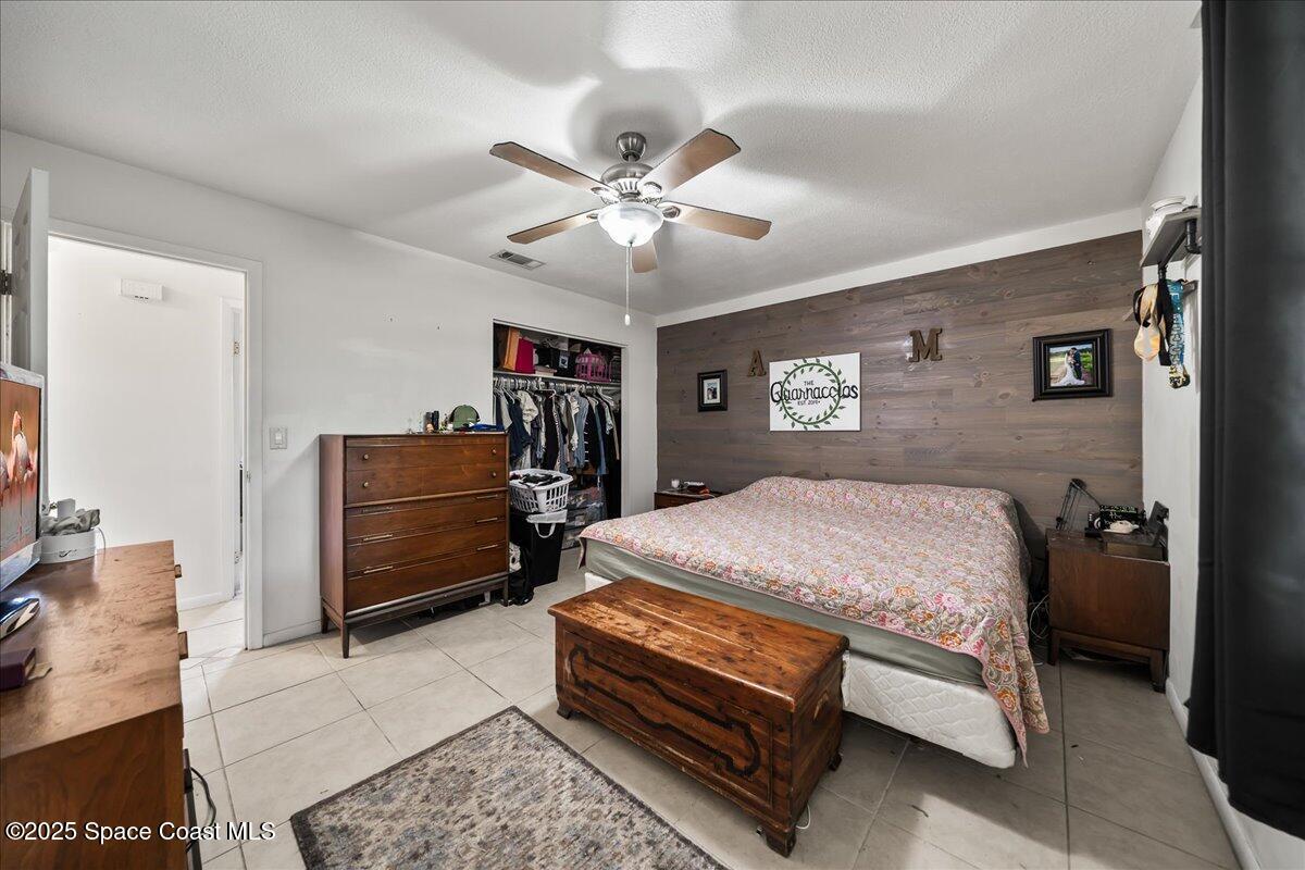 5575 Curtis Boulevard Cocoa, FL 32927 - Photo 12 of 25 a bedroom with a bed and a chandelier