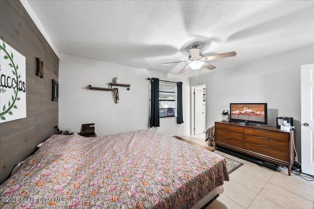 5575 Curtis Boulevard Cocoa, FL 32927 - Photo 13 of 25 a bedroom with a bed and a chandelier