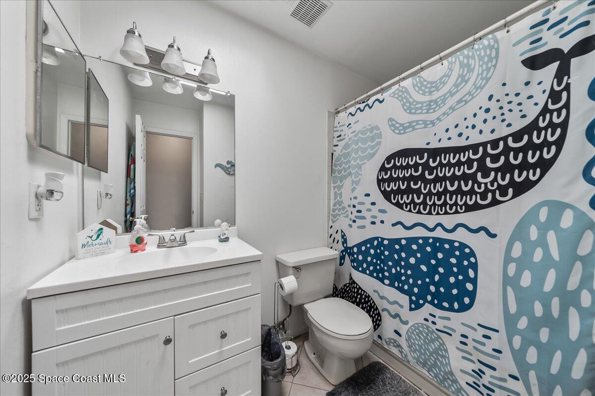 5575 Curtis Boulevard Cocoa, FL 32927 - Photo 17 of 25 a bathroom with a sink mirror vanity and toilet