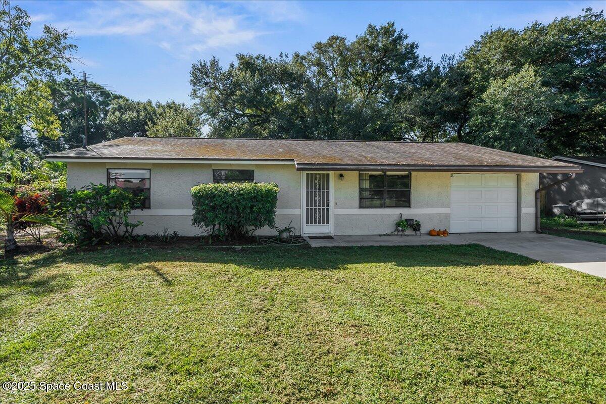5575 Curtis Boulevard Cocoa, FL 32927 - Photo 2 of 25 a front view of house with yard and trees in the background