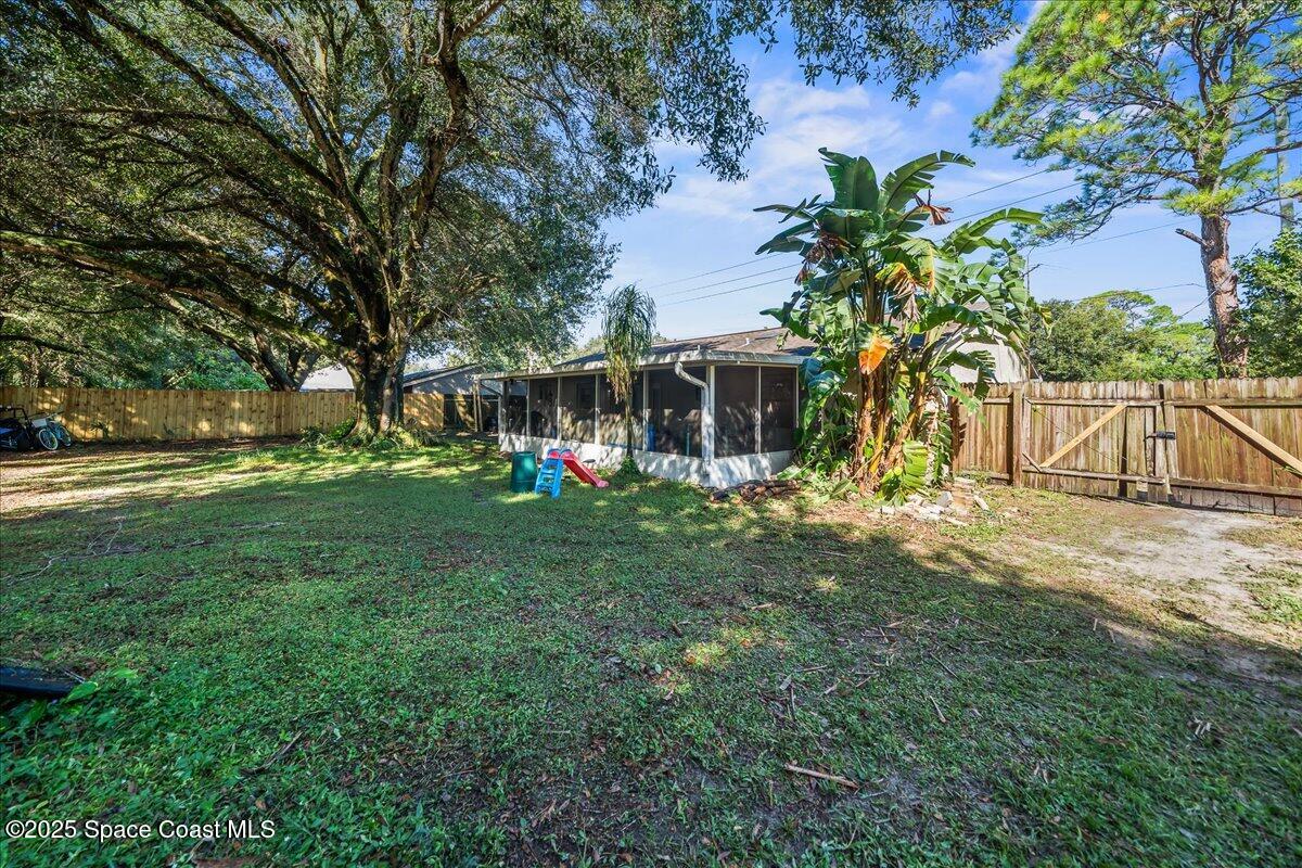 5575 Curtis Boulevard Cocoa, FL 32927 - Photo 22 of 25 a view of a yard with a table and chairs and a large tree