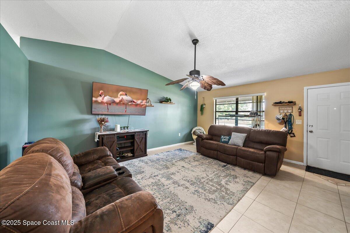 5575 Curtis Boulevard Cocoa, FL 32927 - Photo 3 of 25 a living room with furniture a flat screen tv and a fireplace