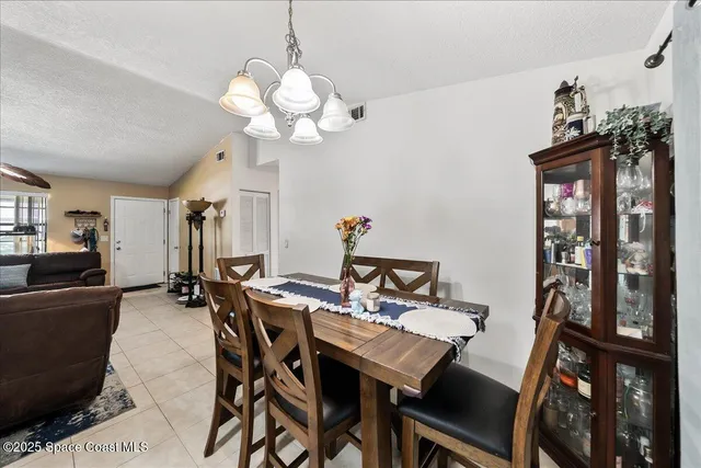 a view of a dining room with furniture and chandelier
