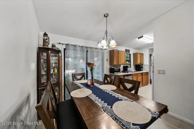 a dining room with furniture a chandelier and wooden floor
