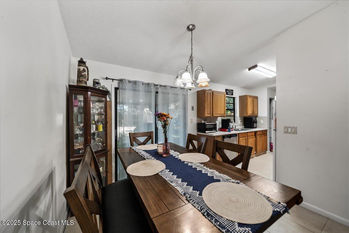 5575 Curtis Boulevard Cocoa, FL 32927 - Photo 7 of 25 a dining room with furniture a chandelier and wooden floor