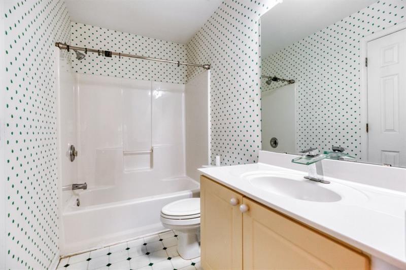 1008 Post Horn Run Lawrenceville, GA 30045 - Photo 24 of 64 a bathroom with a sink a toilet a mirror a vanity and shower