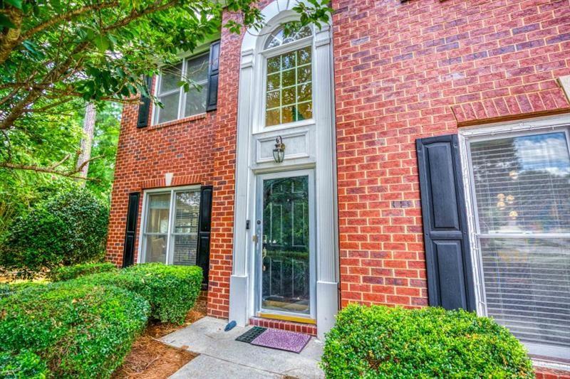 1008 Post Horn Run Lawrenceville, GA 30045 - Photo 44 of 64 a view of a brick house with a large windows and plants