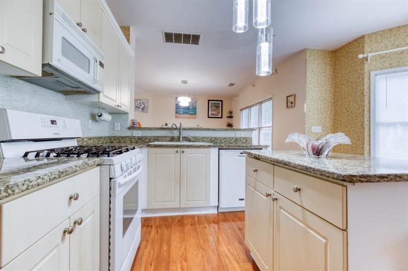 1008 Post Horn Run Lawrenceville, GA 30045 - Photo 49 of 64 a kitchen with granite countertop a sink cabinets stainless steel appliances and a center island