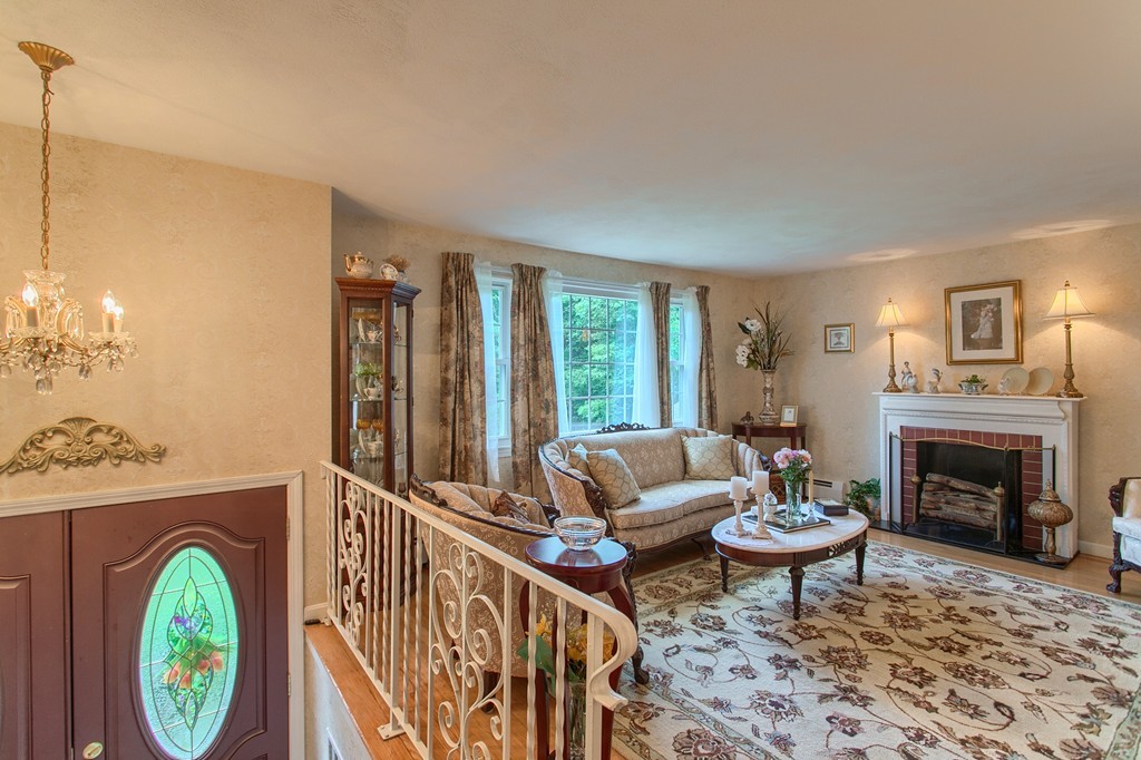4 Dobson Road Chelmsford, MA 01824 - Photo 4 of 25 a living room with furniture a fireplace and a chandelier