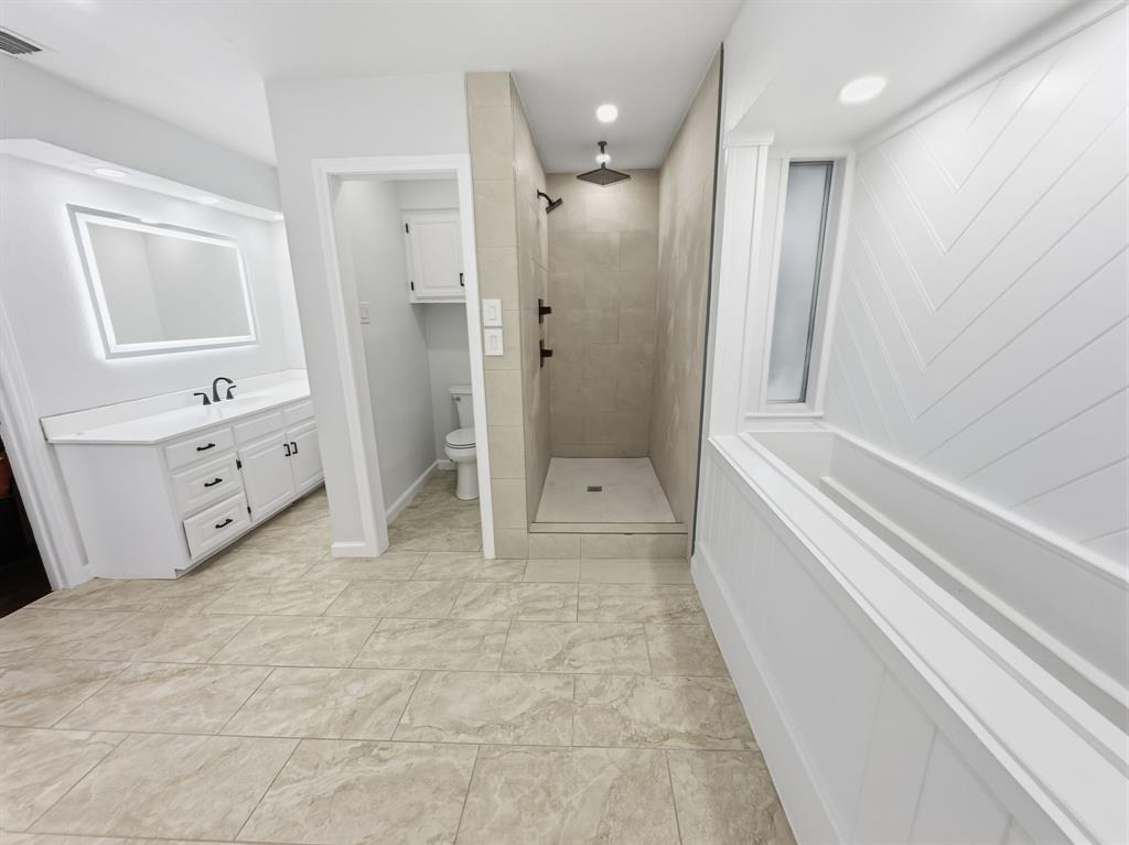 2409 Castle Street Irving, TX 75038 - Photo 17 of 32 a spacious bathroom with a tub shower and mirror