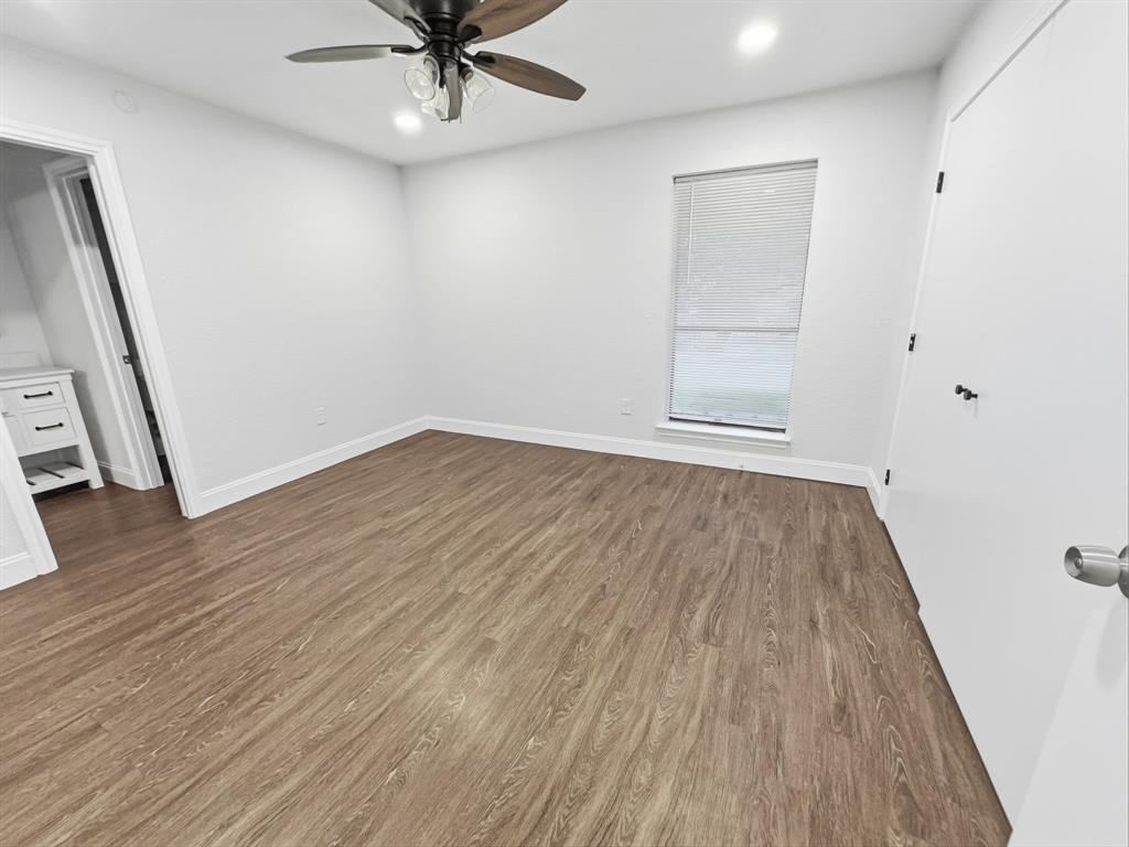 2409 Castle Street Irving, TX 75038 - Photo 21 of 32 an empty room with wooden floor and a ceiling fan