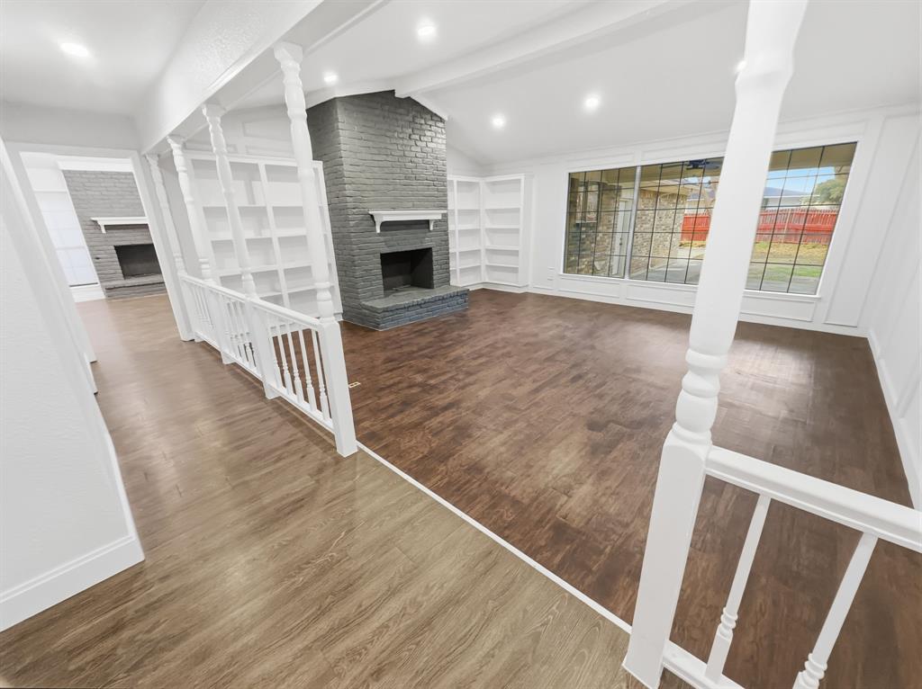 2409 Castle Street Irving, TX 75038 - Photo 5 of 32 wooden floor in an empty room with a fireplace and wooden floor