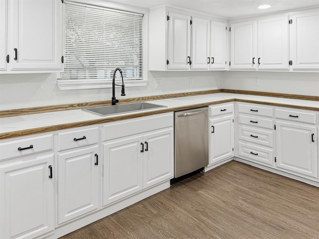 2409 Castle Street Irving, TX 75038 - Photo 8 of 32 a kitchen with white cabinets and sink