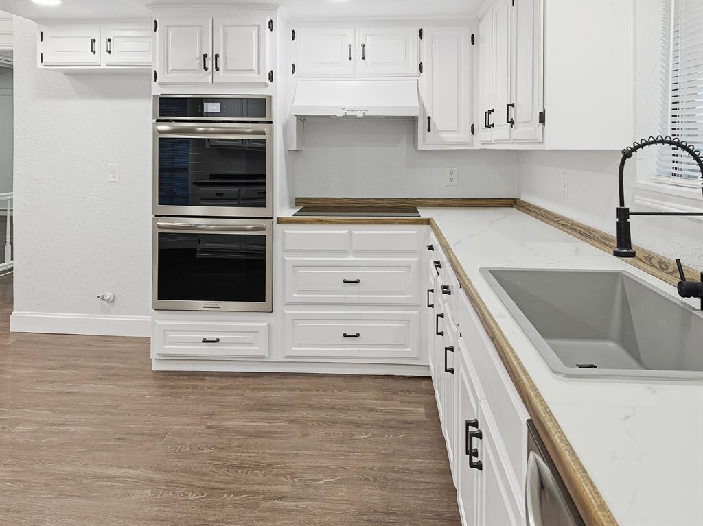 2409 Castle Street Irving, TX 75038 - Photo 9 of 32 a kitchen with stainless steel appliances white cabinets and a sink