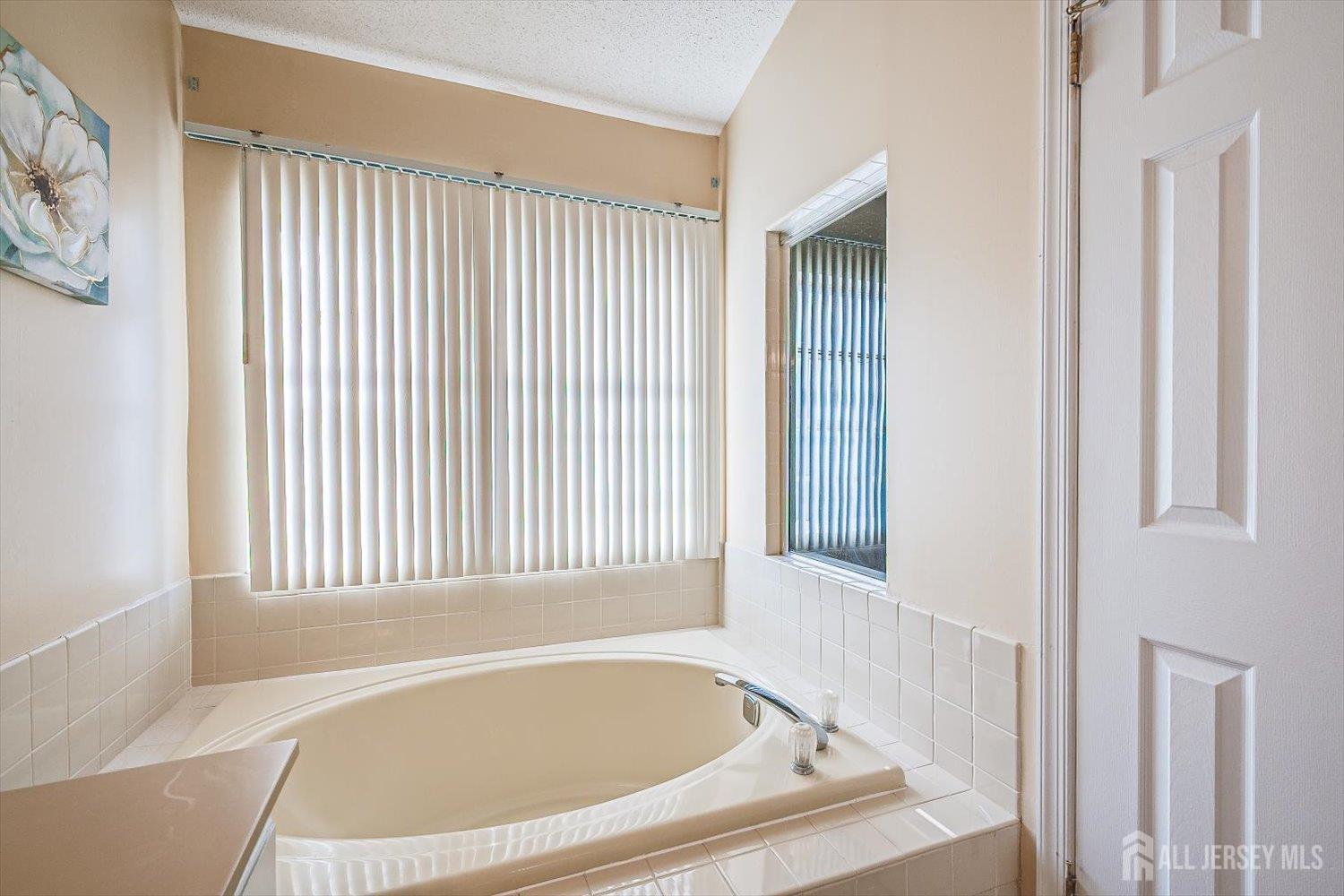 52 Springwood Court Princeton, NJ 08540 - Photo 23 of 34 a white bath tub sitting in a bathroom next to a window
