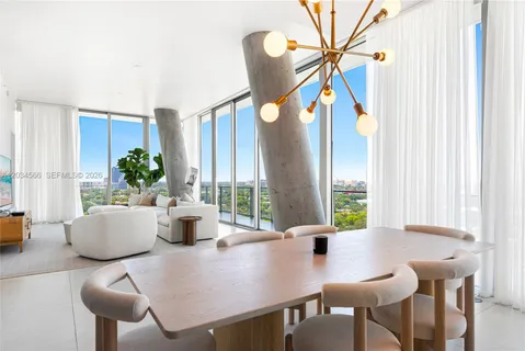 a dining room with furniture and a large window