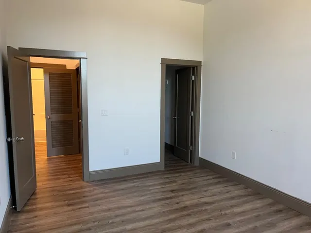 an empty room with wooden floor and closet