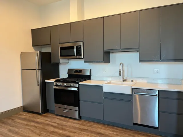 a kitchen with a sink a microwave a refrigerator and cabinets