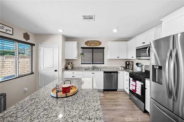 a kitchen with stainless steel appliances granite countertop a refrigerator and a stove