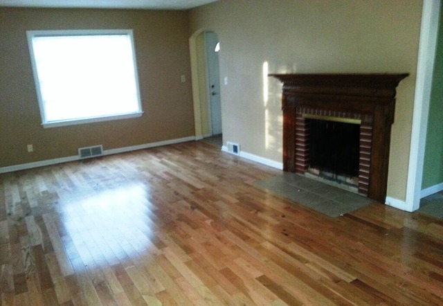 4305 Newburg Road Rockford, IL 61108 - Photo 5 of 11 an empty room with wooden floor fireplace and windows