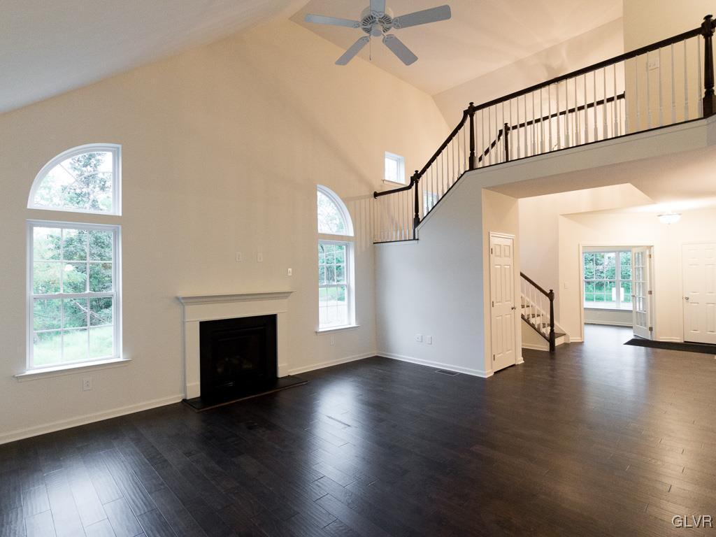 6559 Gun Club Road, Unit 35 Coopersburg, PA 18036 - Photo 12 of 48 an empty room with wooden floor a fireplace and windows