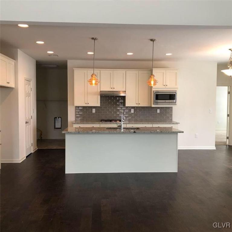 6559 Gun Club Road, Unit 35 Coopersburg, PA 18036 - Photo 17 of 48 a large kitchen with stainless steel appliances a large counter top a stove a refrigerator a sink and a oven