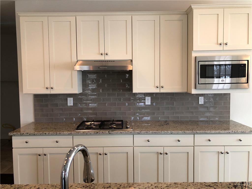 6559 Gun Club Road, Unit 35 Coopersburg, PA 18036 - Photo 18 of 48 a kitchen with granite countertop white cabinets and stainless steel appliances