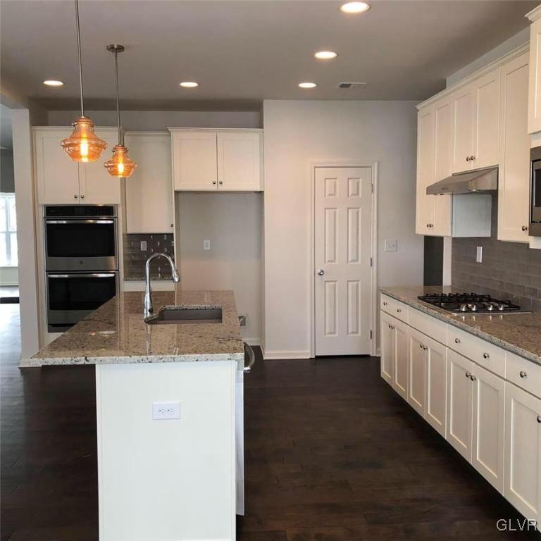 6559 Gun Club Road, Unit 35 Coopersburg, PA 18036 - Photo 19 of 48 a kitchen with stainless steel appliances granite countertop a sink a stove and a refrigerator