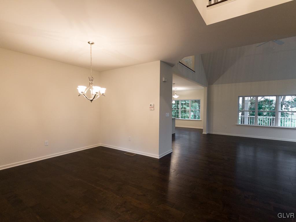 6559 Gun Club Road, Unit 35 Coopersburg, PA 18036 - Photo 9 of 48 an empty room with wooden floor chandelier fan and windows