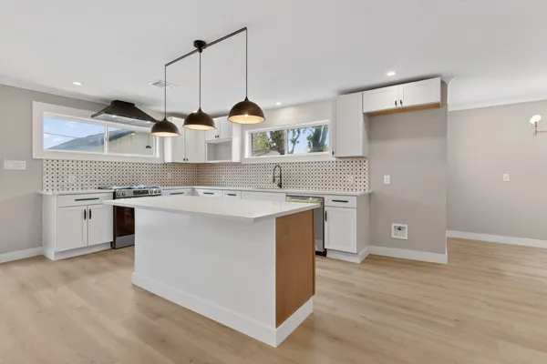 a kitchen with a stove a sink and a refrigerator